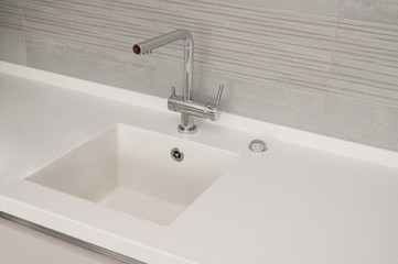 metal faucet in the kitchen, surface and white stone