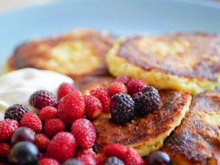 pancakes with berries. and sour cream. Cheesecakes served with lots of fresh berries. Gourmet breakfast - curd cheesecakes, curd pancakes with raspberries, strawberries, blueberries. Close. healthy fo