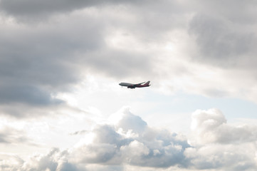 plane in gloomy sky with a gleam of the sun