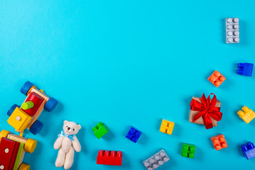Various children's toys on blue background. Space for text in the center of the image.
