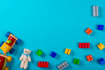 Various children's toys on blue background. Space for text in the center of the image.