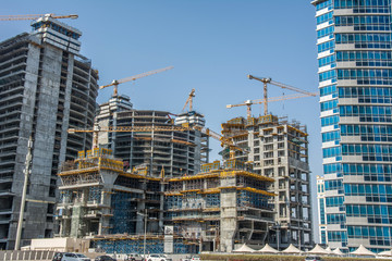 Business center under construction. Cranes and scaffolding at big construction site