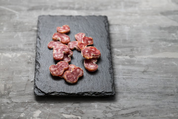 spanish sausage fuet on black ceramic board