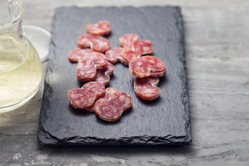 spanish sausage fuet on black ceramic board
