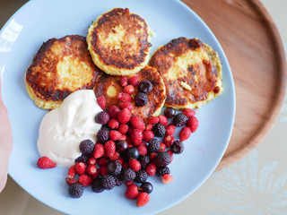 pancakes with berries. and sour cream. Cheesecakes served with lots of fresh berries. Gourmet breakfast - curd cheesecakes, curd pancakes with raspberries, strawberries, blueberries. Close. healthy fo