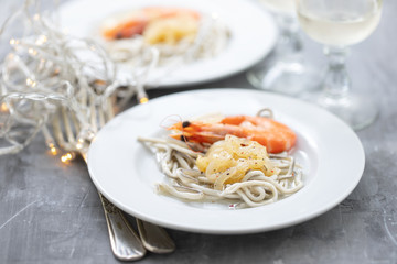 Traditional Spanish food. Gulas with oil and shrimp on white plate.