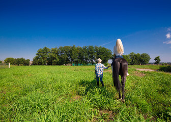 Fototapeta premium Cow girls riding in horse, landscape, green field