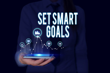 Text sign showing Set Smart Goals. Business photo text giving criteria to guide in the setting of objectives Woman wear formal work suit presenting presentation using smart device