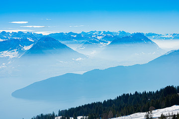 Majestic unique misty blue alpine skyline aerial view panorama of iced Swiss Alps and blue sky. Mount Rigi Switzerland.