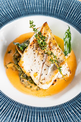 Fried fish fillet. Cod with sauce and herbs