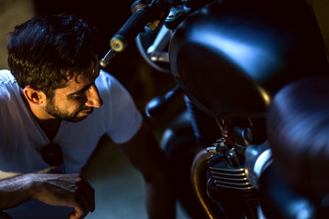  man repairing his motorcycle in the garage.