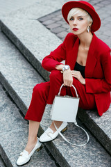 Outdoor full-length fashion portrait of young elegant woman with short blonde hair, wearing total...