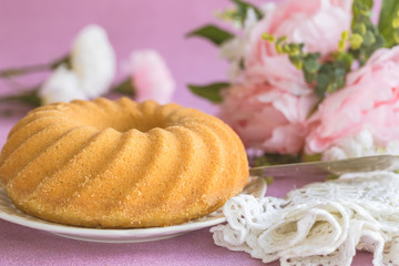 Sponge cake or traditional swedish sockerkaka with flowers and pink background