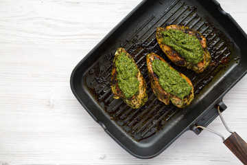 Homemade cooked chimichurri chicken breast in a grilling pan, top view. Flat lay, overhead, from above. Copy space.