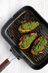 Homemade cooked chimichurri chicken breast in a grilling pan, overhead view. Flat lay, top view, from above. Close-up.