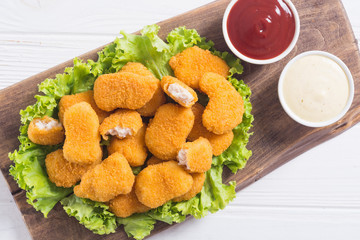 Chicken nuggets in plate on rustic background