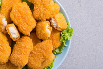 Chicken nuggets in plate on rustic background