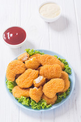 Chicken nuggets in plate on rustic background