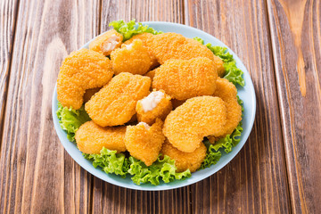 Chicken nuggets in plate on rustic background