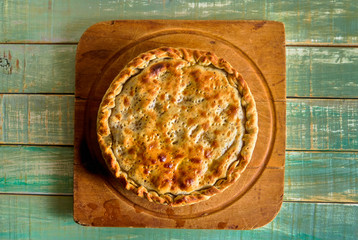 Vegetable pie on board and rustic green table. vegan pie