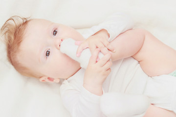 Happy child on the white blanket, blurred background