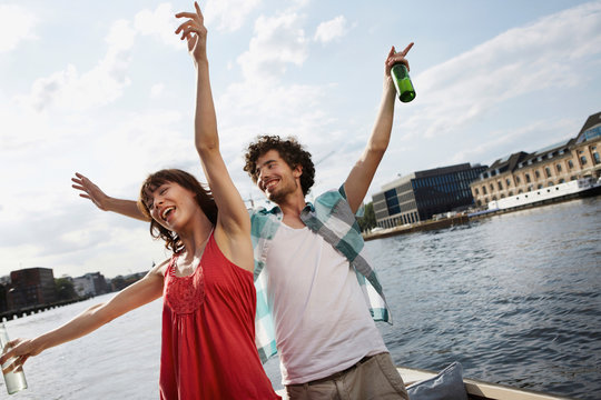 Germany, Berlin, Young couple on motor boat, having fun