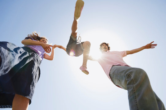 Spain, Mallorca, Family Walking Hand In Hand, Lifting Girl -, Low Angle View