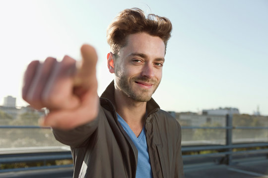 Germany, Berlin, Portrait of a young man pointing, close-up