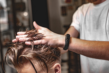Men's haircut and hair styling in a barbershop. Retro photo