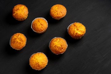 Appetizing muffins stand on a table top view. Traditional pastries on a dark background minimalism.