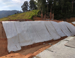 Temporary slope protection during construction using the plastic sheets to prevent soil erosion by rainwater. The protection will be removed after the work done.  