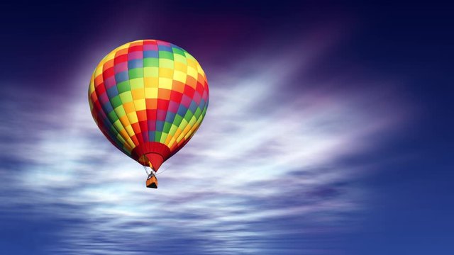 A colorful hot air balloon coming closer against a beautiful sky with sun-rays shining through the clouds.