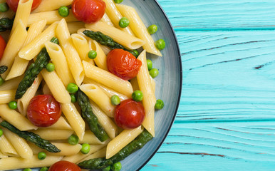 Penne pasta salad with asparagus , tomatoes and peas