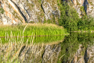 Scenic landscape with rock and reflection in the river, close-up