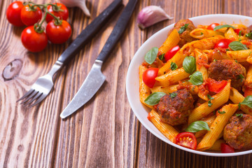 Italian penne pasta with meatballs and tomatoes