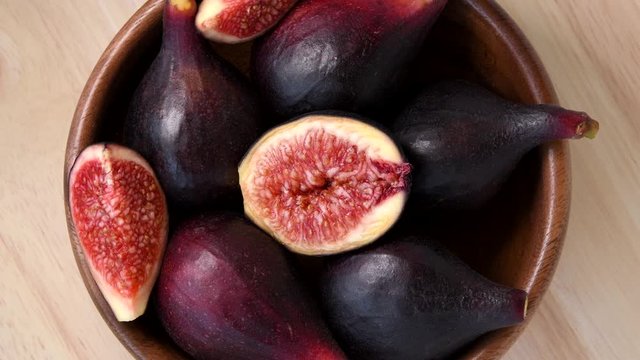 Figs rotating in wooden bowl top view