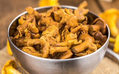 Portion of Preserved chanterelles on wooden background, selective focus