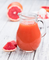 Vintage wooden table with Grapefruit Juice (selective focus)