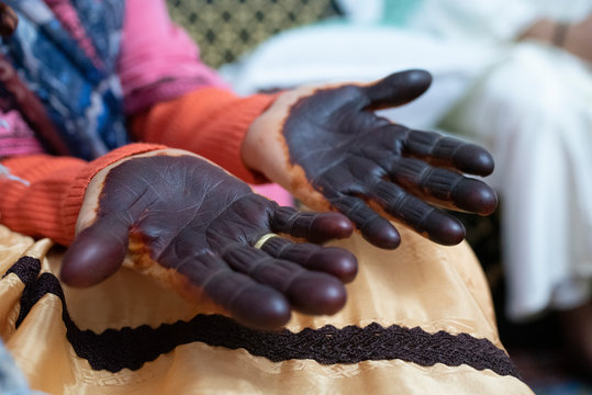 Close up of elderly woman painted hands with henna in celebration.