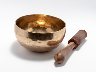 Tibetan singing bowl with percussion stick. Isolated on white background.