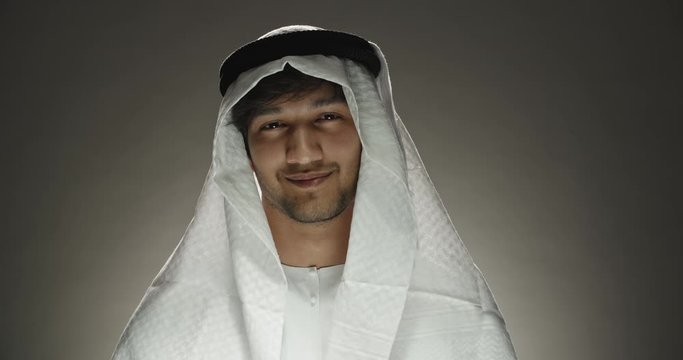 Close up shot of arabian man in traditional white dress attentively listening to someone, nodding in approval and positively smiling 4k