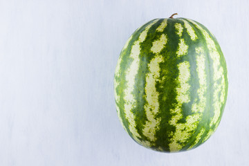 Watermelon on natural white background. Whole watermelon on wooden background. Healthy food for vegan. Copy space