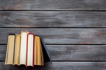 Books on library desk on wooden background top view space for text