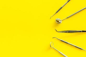 dentist instruments on yellow doctor's office desk background top view mock-up