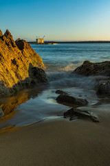 sunset at Corona del Mar State Beach CA USA with great view of the ocean, sun, stone formation, and light