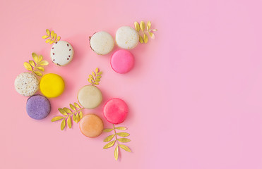 French colorful macaroons cakes flat lay. Small sweet biscuits isolated on pink background. Dessert. Happy bithday and valentine’s day creative minimal concept.  Confectionery. Bakery design element.