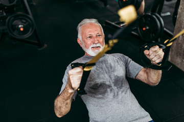 Fototapeta na wymiar Senior man exercising at gym.