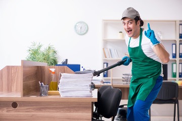 Young handsome contractor cleaning the office