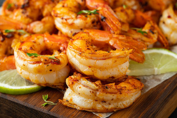 Grilled shrimps or prawns served with lime, garlic and white sauce on a dark concrete background. Seafood