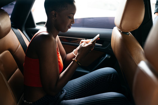 man using her phone in a car